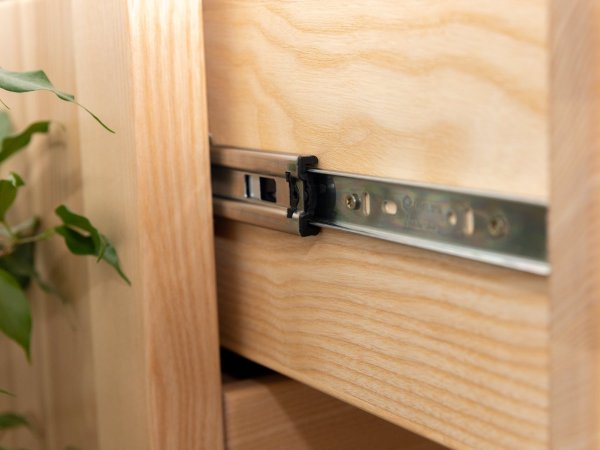 Jasanová masivní postel s čalouněním - detail pojezd